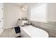 This bathroom showcases a soaking tub, window, and vanity with granite countertops at 220 Seth Ter, Mcdonough, GA 30252