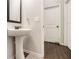This bathroom features a pedestal sink, framed mirror, and hardwood flooring at 220 Seth Ter, Mcdonough, GA 30252