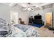 Cozy bedroom featuring a tray ceiling, ceiling fan, and an open doorway to the bathroom at 220 Seth Ter, Mcdonough, GA 30252
