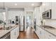 Modern kitchen with white cabinets, granite countertops, and stainless steel appliances at 5750 Sutters Vw, Cumming, GA 30028