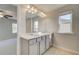 Bathroom featuring double vanity, large mirror, and doorway to bedroom with a ceiling fan at 628 Leafy Branch Way, Mcdonough, GA 30253