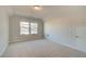 Neutral bedroom featuring neutral carpeting, two windows, and an attic access door at 628 Leafy Branch Way, Mcdonough, GA 30253