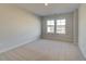 Carpeted bedroom with neutral paint and two sunny windows at 628 Leafy Branch Way, Mcdonough, GA 30253