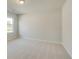 Bright bedroom featuring neutral carpeting, a window, and freshly painted walls at 628 Leafy Branch Way, Mcdonough, GA 30253