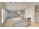 Kitchen island with stainless steel appliances and view into living room at 628 Leafy Branch Way, Mcdonough, GA 30253