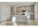 Bright kitchen with gray cabinets, center island, stainless steel appliances, and light wood floors at 628 Leafy Branch Way, Mcdonough, GA 30253