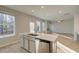 Modern kitchen with stainless steel dishwasher and sink integrated into a center island with white countertop at 628 Leafy Branch Way, Mcdonough, GA 30253