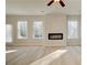 Bright living room with fireplace, ceiling fan, and large windows bringing in natural light at 628 Leafy Branch Way, Mcdonough, GA 30253