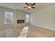 Spacious living room with modern fireplace, two large windows, and a ceiling fan at 628 Leafy Branch Way, Mcdonough, GA 30253