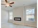 Living room with sleek fireplace, ceiling fan, light wood floors and lots of natural light at 628 Leafy Branch Way, Mcdonough, GA 30253