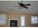 Bright living room with a fireplace, ceiling fan, and large windows at 20 Tara Way, Covington, GA 30016