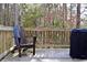 A wooden back deck with a grill and a chair, surrounded by trees and nature at 2127 Dodson Woods Dr, Fairburn, GA 30213