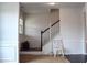 Bright foyer showcasing dark hardwood floors, a staircase with a white banister, and elegant wall paneling at 2127 Dodson Woods Dr, Fairburn, GA 30213