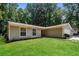 Single story home with grey siding, green lawn and trees at 5377 Martins Crossing Rd, Stone Mountain, GA 30088