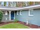 Close-up of the front porch with blue door and a well-manicured lawn with brick exterior at 1714 Fort Valley Sw Dr, Atlanta, GA 30311