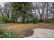 A spacious backyard featuring a mature tree, a concrete patio and a large lawn at 2980 Laguna Dr, Decatur, GA 30032
