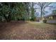 Spacious backyard featuring mature trees, lush green space, and a view of the home's exterior at 2980 Laguna Dr, Decatur, GA 30032