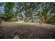 Backyard view of the house featuring mature trees, green space, and a small patio at 2980 Laguna Dr, Decatur, GA 30032