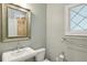 Charming bathroom with pedestal sink, decorative mirror, and a leaded glass window at 1031 Eulalia Ne Rd, Atlanta, GA 30319