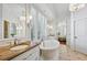 Bright bathroom with tub, shuttered windows, marble countertops, and decorative lighting at 1031 Eulalia Ne Rd, Atlanta, GA 30319