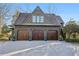 Three-car garage with wooden doors, enhanced by a beautiful paver driveway at 1031 Eulalia Ne Rd, Atlanta, GA 30319