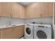 Modern laundry room with new washer, dryer, and light wood cabinets at 2425 Peachtree Road # 1008, Atlanta, GA 30305