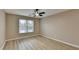 This bedroom features neutral walls, ceiling fan, and a window that provides natural light at 4815 Diggers Way, Sugar Hill, GA 30518