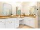 Bathroom with dual vanities with marble countertops and white cabinets at 1069 Saint James Ne Xing, Atlanta, GA 30319