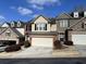 Tan and brown townhome with a two-car garage and landscaping at 5800 Oakdale Rd # 103, Mableton, GA 30126