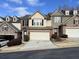Tan and brown townhome with a two-car garage and landscaping at 5800 Oakdale Rd # 103, Mableton, GA 30126