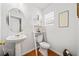 Small half bathroom with pedestal sink, toilet, and white shelving at 151 Nacoochee Way, Canton, GA 30114