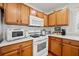 Efficient kitchen featuring wood cabinets, white appliances and hardwood floors at 151 Nacoochee Way, Canton, GA 30114