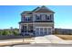 Two story house with gray siding, brick accents, and a three-car garage at 201 Augusta Walk, Canton, GA 30114