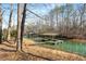 Waterfront property featuring a covered dock with wood storage nestled in a tranquil, tree-lined cove at 3520 Still Rd, Cumming, GA 30041