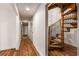 Hallway with white walls, wood floors, and a unique spiral staircase leading to the upper level at 3520 Still Rd, Cumming, GA 30041