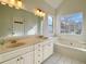 Bright bathroom boasts double sinks, a soaking tub, and a large mirror at 4299 High Country Dr, Douglasville, GA 30135