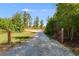 Gravel driveway leading to house with trees and gate at 701 Jones Mill Rd, Whitesburg, GA 30185
