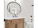 Light-toned bathroom with an oval mirror and a wooden vanity at 1010 Edgewater Dr, Atlanta, GA 30328