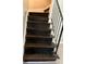 A full view of dark stained wood stairs with white risers, and black iron railing at 1971 Annette Ln, Austell, GA 30106