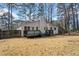 Back exterior of home featuring a deck and a yard with mature trees at 3364 Sheree Trl, Stone Mountain, GA 30087