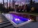 Night view of the pool with colorful lighting at 1974 Ellwyn Dr, Brookhaven, GA 30341