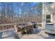 Outdoor back deck with a dining table, wicker chairs, gas grill, and wooded backyard at 2109 Rocky Falls Nw Ct, Kennesaw, GA 30152