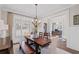 Elegant dining room with wainscoting, stylish chandelier, and view into the home office at 2109 Rocky Falls Nw Ct, Kennesaw, GA 30152