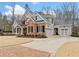 Stunning brick and gray home with a three-car garage and a circular brick paver driveway at 2109 Rocky Falls Nw Ct, Kennesaw, GA 30152