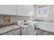 The laundry room features modern machines, granite counters, and white cabinets at 2109 Rocky Falls Nw Ct, Kennesaw, GA 30152