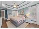 Comfortable main bedroom featuring a tray ceiling and a view into the en suite bath at 2109 Rocky Falls Nw Ct, Kennesaw, GA 30152