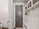 Mudroom with storage hooks, cubbies, and bench seating adjacent to a half bathroom and gray door at 2109 Rocky Falls Nw Ct, Kennesaw, GA 30152