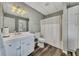 Clean basement bathroom with white vanity, shower, and vinyl flooring at 409 E Point Dr, Canton, GA 30115