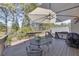 Relaxing deck with umbrella, patio furniture, and grill, overlooking wooded area at 409 E Point Dr, Canton, GA 30115