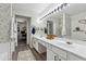 Bright bathroom with a double sink vanity, modern lighting, and stylish herringbone patterned accent wall at 133 Regent Pl, Woodstock, GA 30188